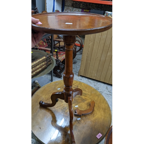 329 - An Art Deco period walnut three tier circular table with quarter cut and glass top, supported on sla... 