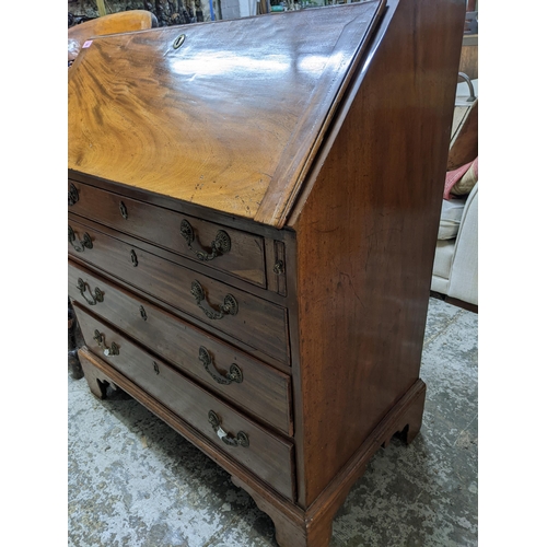 367 - A Georgian mahogany bureau, fall flap revealing a pigeonhole and drawer interior, short drawer over ... 