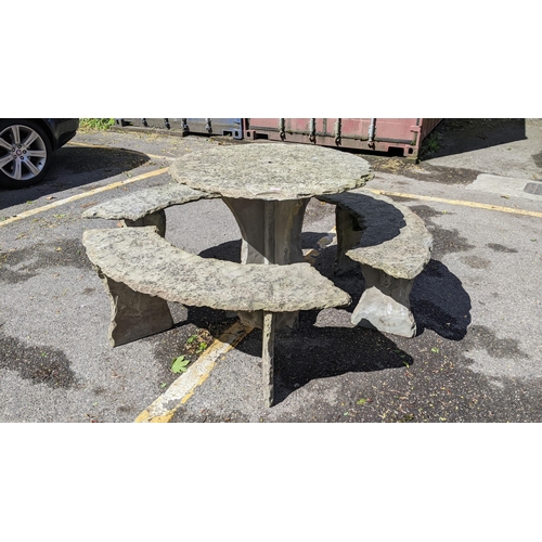 501 - A modern carved slate circular garden table and three benches to surround, (table and base, benches ... 