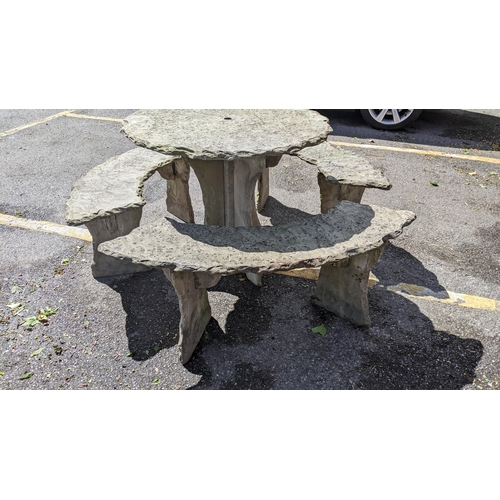 501 - A modern carved slate circular garden table and three benches to surround, (table and base, benches ... 