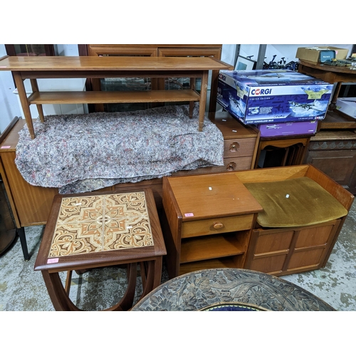 519 - A mid-century teak coffee table with undertier, a teak telephone seat with drawer, open shelves, and... 