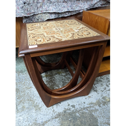 519 - A mid-century teak coffee table with undertier, a teak telephone seat with drawer, open shelves, and... 