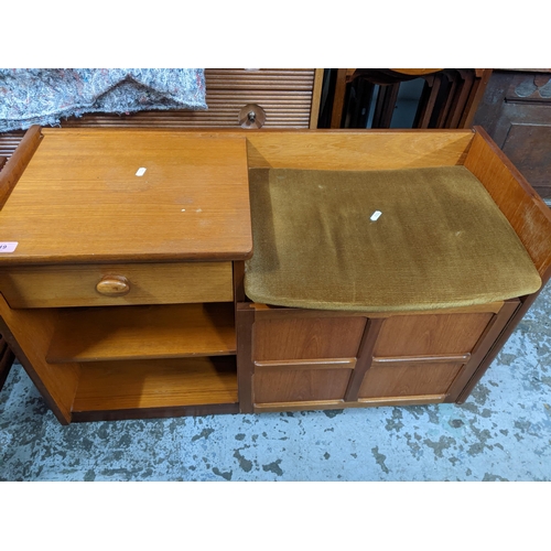 519 - A mid-century teak coffee table with undertier, a teak telephone seat with drawer, open shelves, and... 