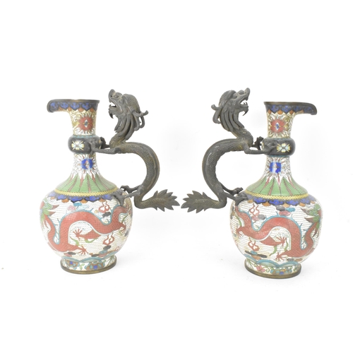 109 - A pair of Chinese late Qing dynasty cloisonne ewers, both having a handle modelled in the form of a ... 