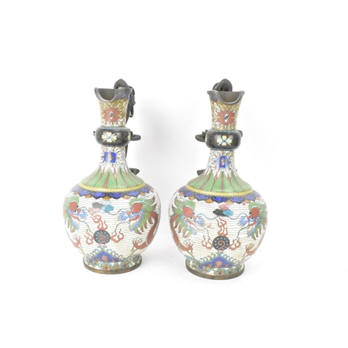 109 - A pair of Chinese late Qing dynasty cloisonne ewers, both having a handle modelled in the form of a ... 