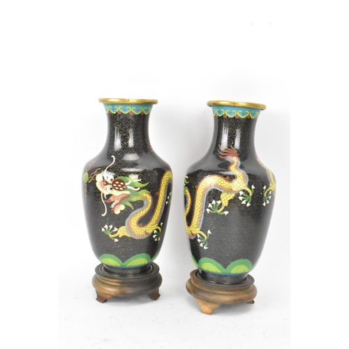 115 - A pair of Chinese mid 20th century cloisonne vases, with black grounds decorated with confronting dr... 