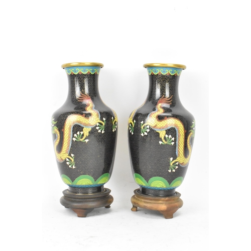 115 - A pair of Chinese mid 20th century cloisonne vases, with black grounds decorated with confronting dr... 