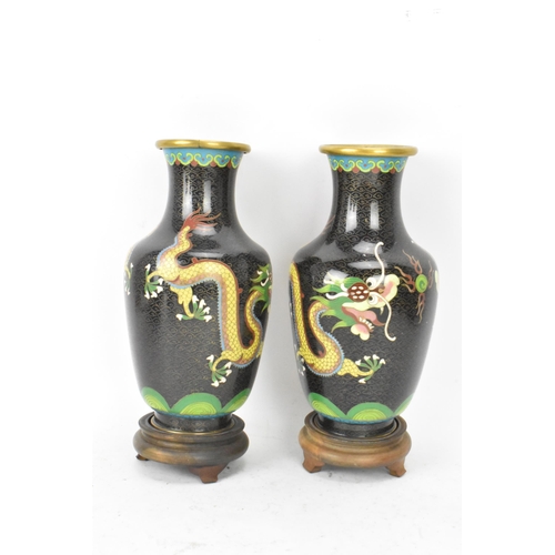 115 - A pair of Chinese mid 20th century cloisonne vases, with black grounds decorated with confronting dr... 