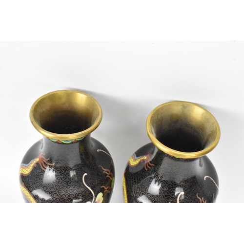 115 - A pair of Chinese mid 20th century cloisonne vases, with black grounds decorated with confronting dr... 