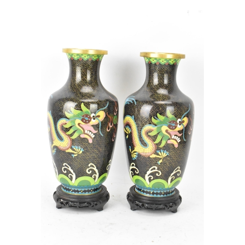 116 - A pair of Chinese mid 20th century cloisonne vases and a bowl, all with black grounds decorated with... 