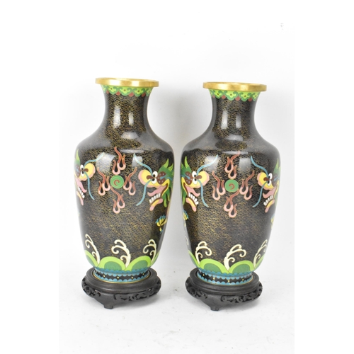 116 - A pair of Chinese mid 20th century cloisonne vases and a bowl, all with black grounds decorated with... 