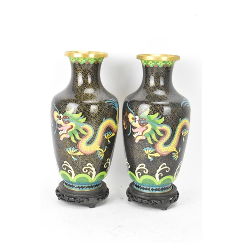 116 - A pair of Chinese mid 20th century cloisonne vases and a bowl, all with black grounds decorated with... 