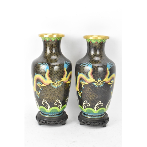 116 - A pair of Chinese mid 20th century cloisonne vases and a bowl, all with black grounds decorated with... 