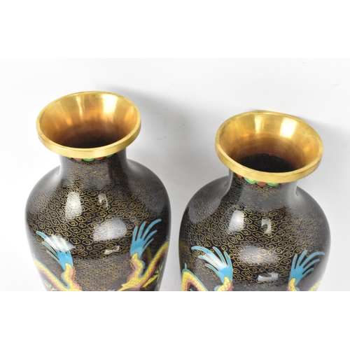 116 - A pair of Chinese mid 20th century cloisonne vases and a bowl, all with black grounds decorated with... 