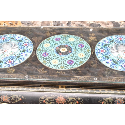 125 - A Chinese 20th century cloisonne coffee table, the black  lacquered low coffee table with a rectangu... 