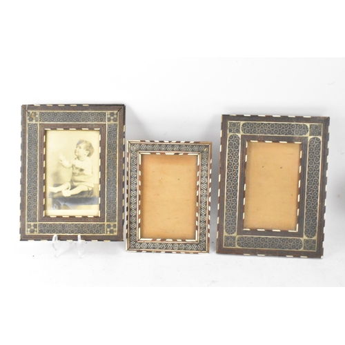 127 - Three similar Persian late Qajar dynasty photograph frames, the profusely inlaid frames having micro... 