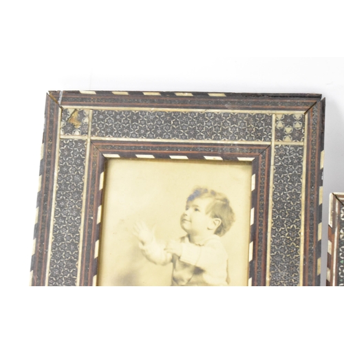 127 - Three similar Persian late Qajar dynasty photograph frames, the profusely inlaid frames having micro... 