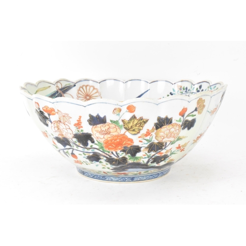 130 - A Japanese Edo period Arita Imari porcelain punch bowl, circa 1700, having a shaped rim and fluted b... 