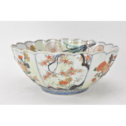 130 - A Japanese Edo period Arita Imari porcelain punch bowl, circa 1700, having a shaped rim and fluted b... 