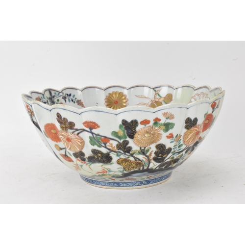 130 - A Japanese Edo period Arita Imari porcelain punch bowl, circa 1700, having a shaped rim and fluted b... 