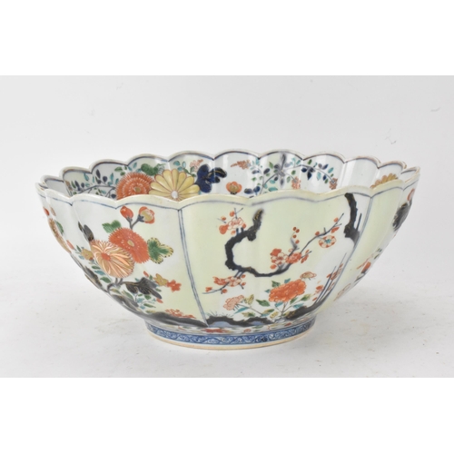 130 - A Japanese Edo period Arita Imari porcelain punch bowl, circa 1700, having a shaped rim and fluted b... 