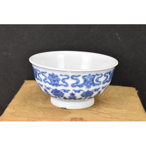 137 - A Chinese blue and white tea bowl, decorated with lotus flowers among stylized scroll decoration wit... 