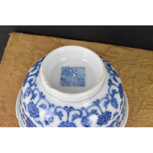 137 - A Chinese blue and white tea bowl, decorated with lotus flowers among stylized scroll decoration wit... 