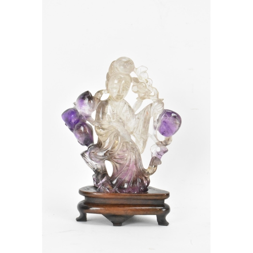 139 - A 20th century Chinese carved amethyst figure of Guanyin, the goddess of mercy, in a seated position... 