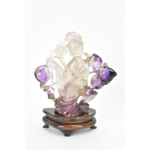 139 - A 20th century Chinese carved amethyst figure of Guanyin, the goddess of mercy, in a seated position... 