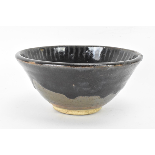 141 - A Chinese Cizhou type bowl, of conical form and covered in a dark lustrous glaze falling short of th... 