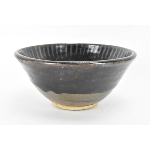 141 - A Chinese Cizhou type bowl, of conical form and covered in a dark lustrous glaze falling short of th... 