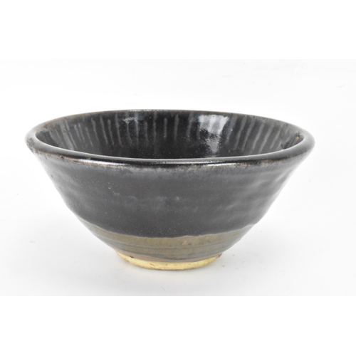 141 - A Chinese Cizhou type bowl, of conical form and covered in a dark lustrous glaze falling short of th... 