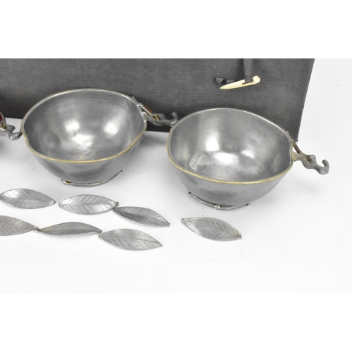 144 - A set of six Chinese pewter bowls, each having a shaped rim and fluted body, the handles in the form... 