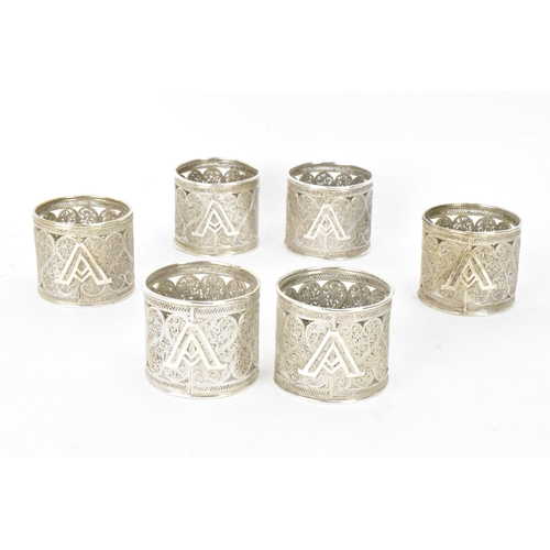 149 - A set of six early 20th century Middle Eastern white metal filigree napkin rings, elaborately pierce... 