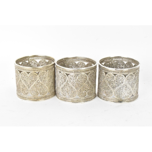 149 - A set of six early 20th century Middle Eastern white metal filigree napkin rings, elaborately pierce... 