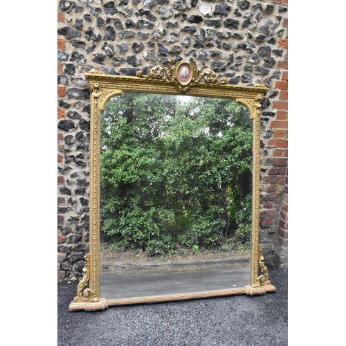 152 - A 19th century French Louis XVI style large gilt wall mirror, having a sevres style painted plaque d... 