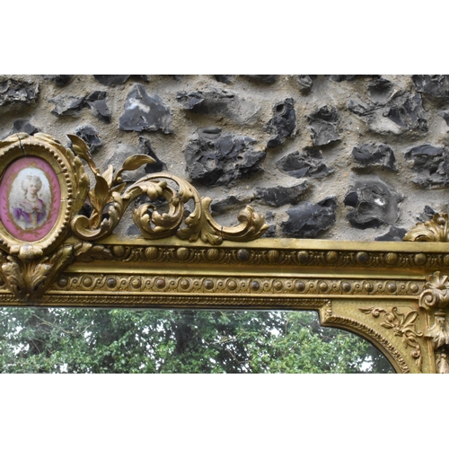 152 - A 19th century French Louis XVI style large gilt wall mirror, having a sevres style painted plaque d... 