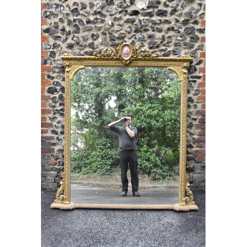 152 - A 19th century French Louis XVI style large gilt wall mirror, having a sevres style painted plaque d... 