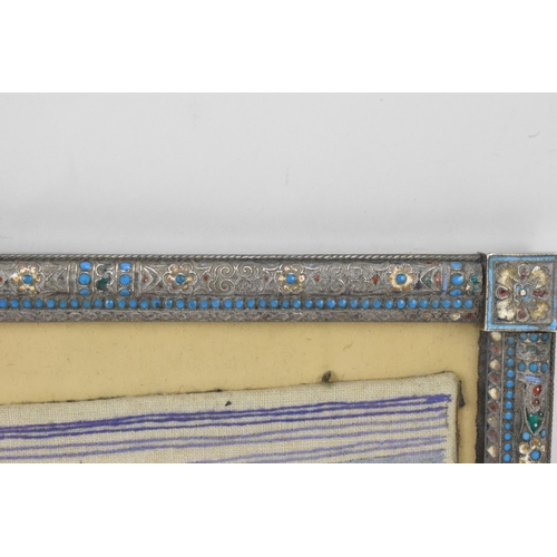 153 - A Russian silver early 20th century champleve enamel photograph frame, inset with a tapestry and bor... 