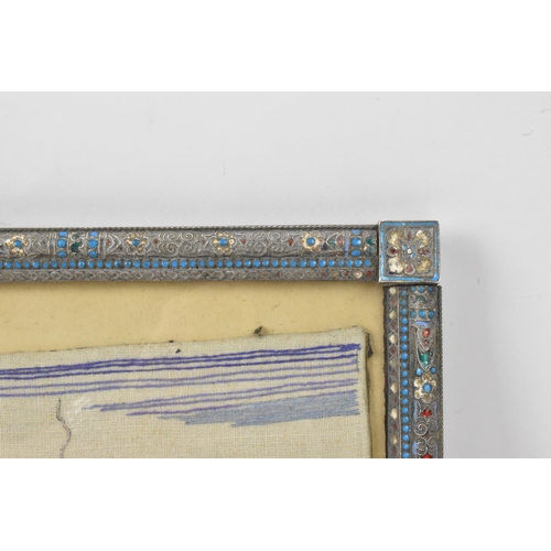 153 - A Russian silver early 20th century champleve enamel photograph frame, inset with a tapestry and bor... 