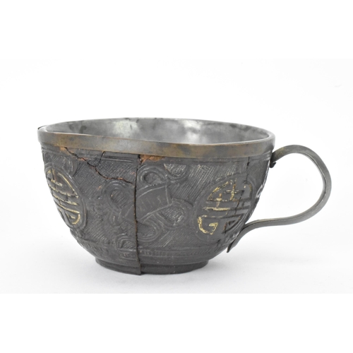 20 - A Chinese late 19th/early 20th century coconut carved cup and saucer, both with pewter liners and th... 