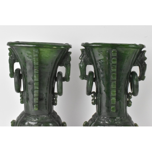 31 - A pair of Chinese 20th century jadeite vases, of flattened baluster shape with archaistic relief dec... 