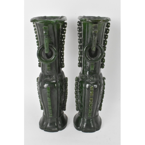 31 - A pair of Chinese 20th century jadeite vases, of flattened baluster shape with archaistic relief dec... 