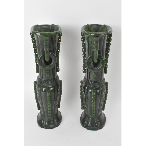 31 - A pair of Chinese 20th century jadeite vases, of flattened baluster shape with archaistic relief dec... 