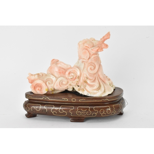 33 - A Chinese 20th century coral carving depicting a laughing Buddha with child among a nautical scenery... 