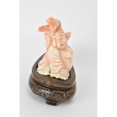 33 - A Chinese 20th century coral carving depicting a laughing Buddha with child among a nautical scenery... 