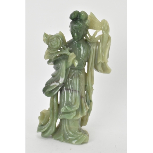 34 - Two Chinese 20th century jadeite carved figures, the green example modeled holding a fan and flowers... 