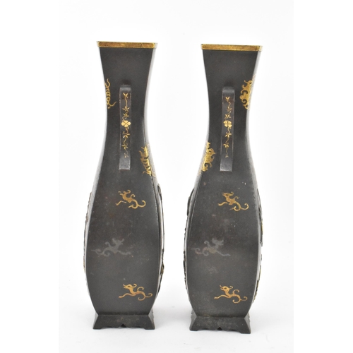 43 - A pair of Japanese Meiji period iron vases, decorated with panels depicting birds and flowers in rel... 