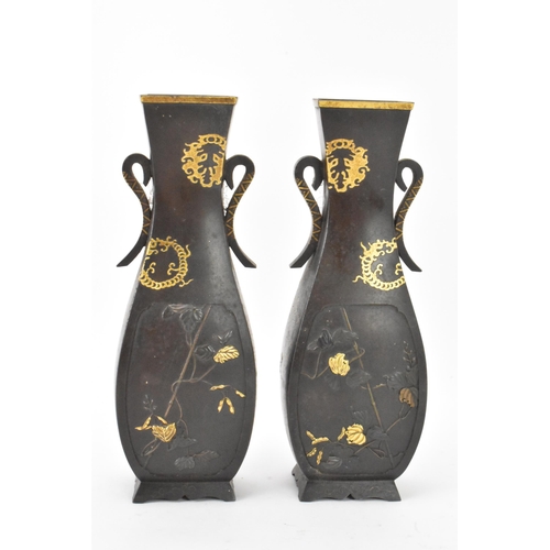 43 - A pair of Japanese Meiji period iron vases, decorated with panels depicting birds and flowers in rel... 