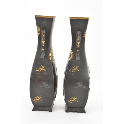 43 - A pair of Japanese Meiji period iron vases, decorated with panels depicting birds and flowers in rel... 